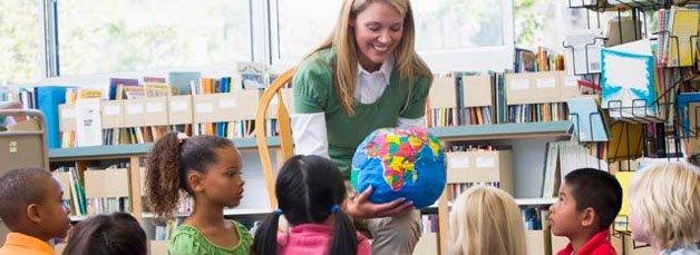 Teacher with globe in classroom